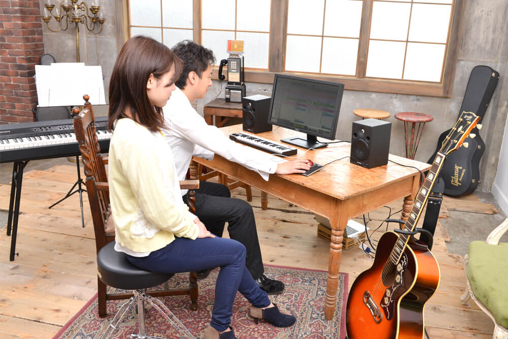 プロの作曲家である講師から曲作りについて指導を受ける生徒