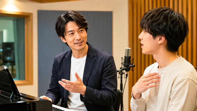 ボーカルレッスンで信頼感のあるボイストレーナーが生徒の歌い方や歌の悩みにアドバイスしている様子